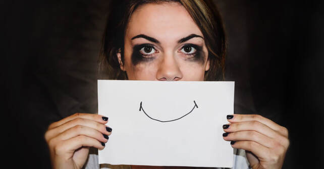 Woman who was clearly crying with a hand drawn smile over her mouth. Masking depression